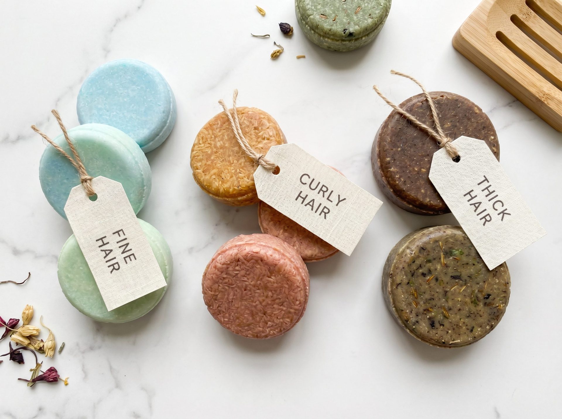Natural shampoo bars in different colours grouped by hair type, with tags for fine, curly and thick hair